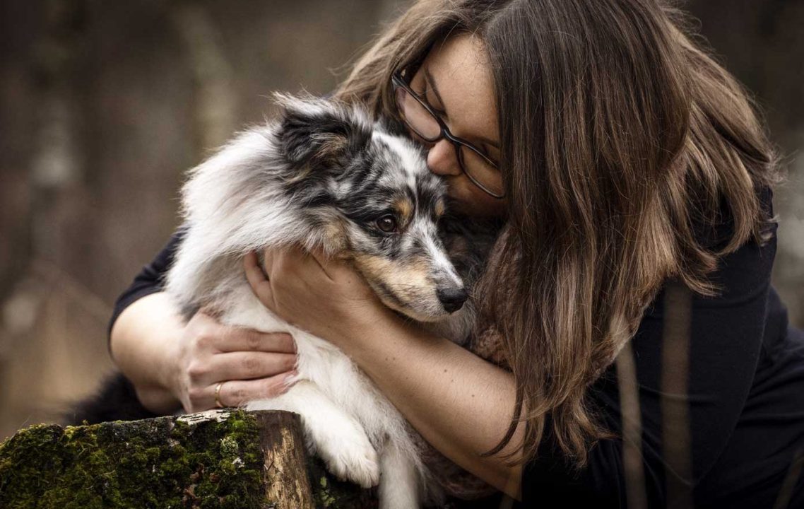 Frau küsst kleinen Hund